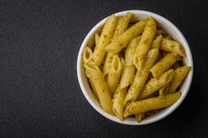 delicioso Fresco pasta pasta con verde pesto salsa con albahaca, sal y especias foto