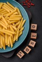 Raw penne pasta from whole grain wheat varieties with salt and spices photo