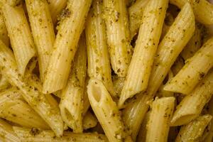 delicioso Fresco pasta pasta con verde pesto salsa con albahaca, sal y especias foto