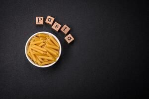 Raw penne pasta from whole grain wheat varieties with salt and spices photo