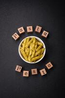 Delicious fresh pasta penne with green pesto sauce with basil, salt and spices photo