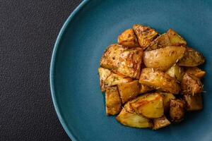 Delicious crispy fried potato wedges with salt, spices and herbs photo