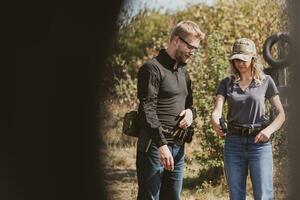 A weapons instructor teaches a girl to shoot a pistol at a firing range photo