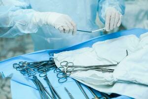 A nurse prepares medical instruments for surgery for surgeons photo