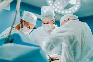 A highly qualified team of surgeons performs a complex operation to remove a pancreatic cyst using medical instruments photo