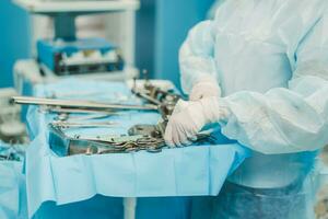 A nurse prepares medical instruments for surgery for surgeons photo