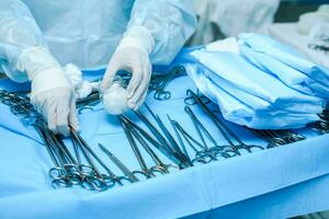 A nurse prepares medical instruments for surgery for surgeons photo