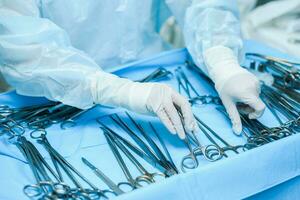 A nurse prepares medical instruments for surgery for surgeons photo