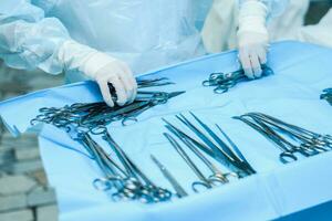 un enfermero prepara médico instrumentos para cirugía para cirujanos foto