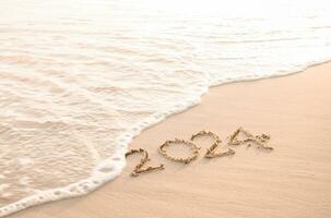 2024 year written on the beach in the sunset time. New Year 2024 concept photo