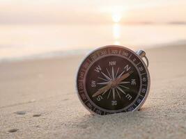 cerca arriba Brújula en el playa con luz de sol foto