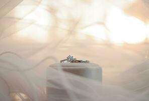 Diamond engagement wedding rings on bridal veil. Wedding accessories, Valentine's day and Wedding day concept. photo