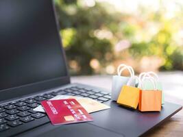 Shopping bags and Credits cards on a laptop keyboard. Concepts about online shopping that offers home delivery photo