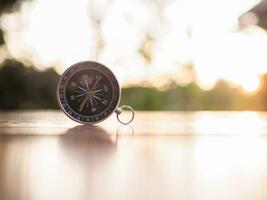 Close up compass on table in the sunset time. The concept of world tourism day, Searching the right directions and Travel photo