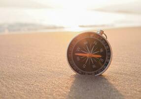 Close up compass on the beach with sunlight photo