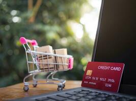 creditos tarjetas en un ordenador portátil teclado con cajas en un carretilla. conceptos acerca de en línea compras ese ofertas hogar entrega foto