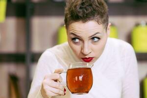Beautiful girl drinks green tea in coffee photo