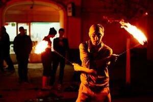 The guy on the street performs with fire torches photo