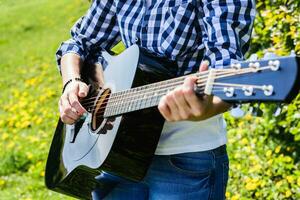 girl on a green meadow playing guitar photo