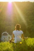 Girl is engaged in meditation on the nature photo