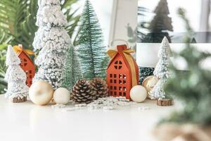 Festive scene is a beautiful Christmas tree adorned, with Christmas balls, pine cones, and a red house gift box tied with golden ribbon. Christmas mockup with space for text. photo