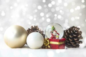 Christmas balls, Santa Claus in a Snow globe, and Pine cones on a white Cloth, set Against a Red Background and exquisite bokeh. New Year Celebration Atmosphere, about of Important day. photo