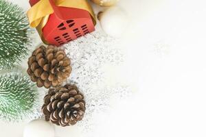 Top view festive scene is a beautiful Christmas tree adorned, with Christmas balls, pine cones, and a red house gift box tied with golden ribbon. Christmas mockup with space for text. photo