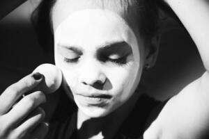 pequeño niña haciendo maquillaje mímica en el calle foto