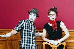 two mimes posing against a red wall background photo