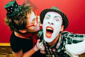 two mimes posing against a red wall background photo