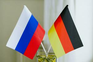 alemán y ruso bandera son atascado juntos en un vaso foto