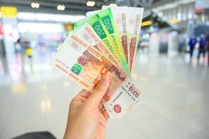 Close-up of someone holding and showing variety of Russian banknotes in the hand. The Russian ruble is the currency of the Russian Federation. photo