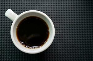 un taza de negro café en mesa. negro café es Rico en antioxidantes, cuales lata lucha célula dañar y reducir tu riesgo de grave salud condiciones. foto