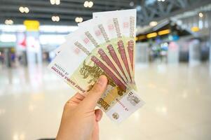 Close-up of someone holding and showing group of 100rub Russian banknotes in the hand. The Russian ruble is the currency of the Russian Federation. photo