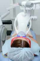 the patient undergoes a procedure for teeth whitening with an ultraviolet lamp photo