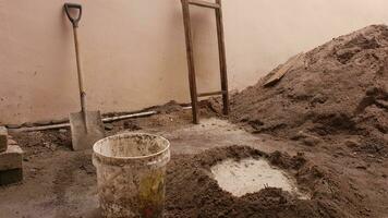 shovels, sieve buckets and also mounds of cement filled with water for construction photo