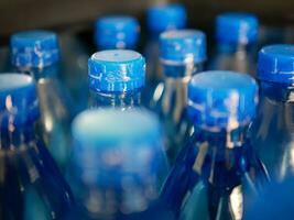 Close-up of Large Number of Packed Blue Bottled Drinking Water with Blue Caps.drinking water bottle background photo