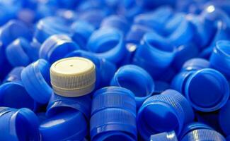 Grey plastic bottle caps on top to depict the concept of standing out from the crowd, dare to be different, odd man out, success or a leadership concept. photo