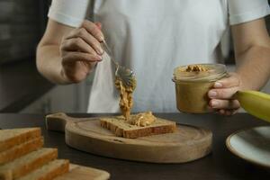 Peanut butter - woman preparing breakfast. photo