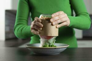 mujer comer vegano ensalada desde tarro con garbanzo. sano hecho en casa comida concepto. foto