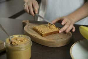 Peanut butter - woman preparing breakfast. photo