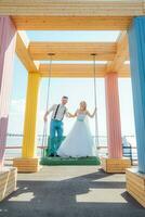 the bride and groom ride on a swing photo