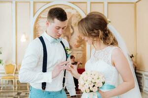 the bride and groom wear each other's rings photo