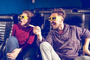 guy and girl 3d glasses are very worried while watching a movie in a cinema photo