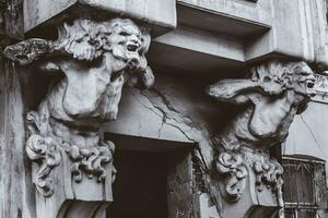 bust of concrete of a terrible woman on the facade of an old house photo