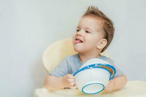 the kid in the kitchen eats milk porridge photo