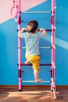 little child climbs the stairs in the gym photo