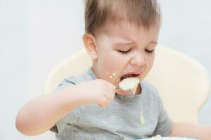 the kid in the kitchen eats milk porridge photo