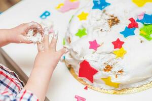 pequeño bebé toques su cumpleaños pastel cuales mentiras en el mesa foto