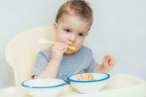 the kid in the kitchen eats milk porridge photo